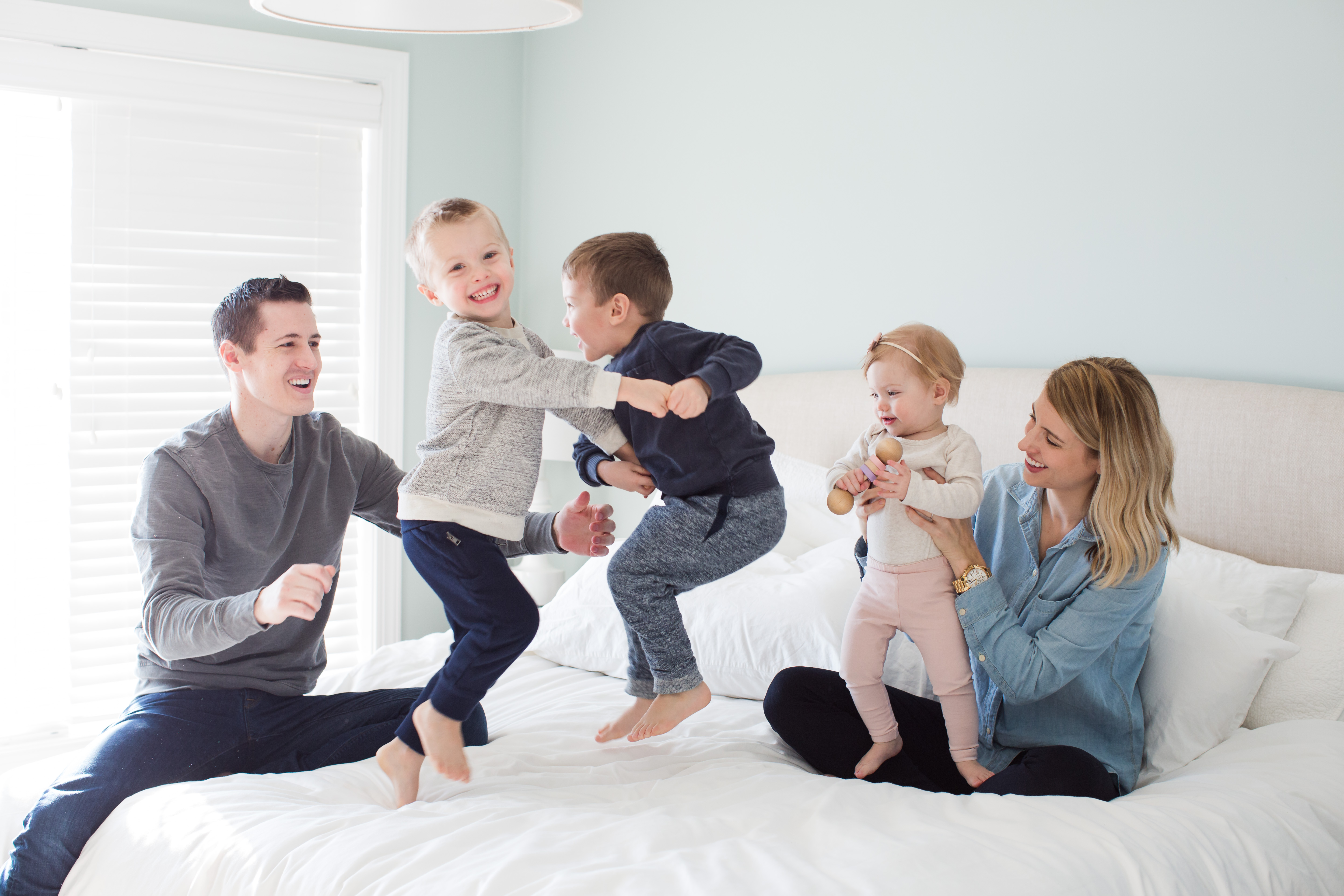 Kids jumping on bed with parents
